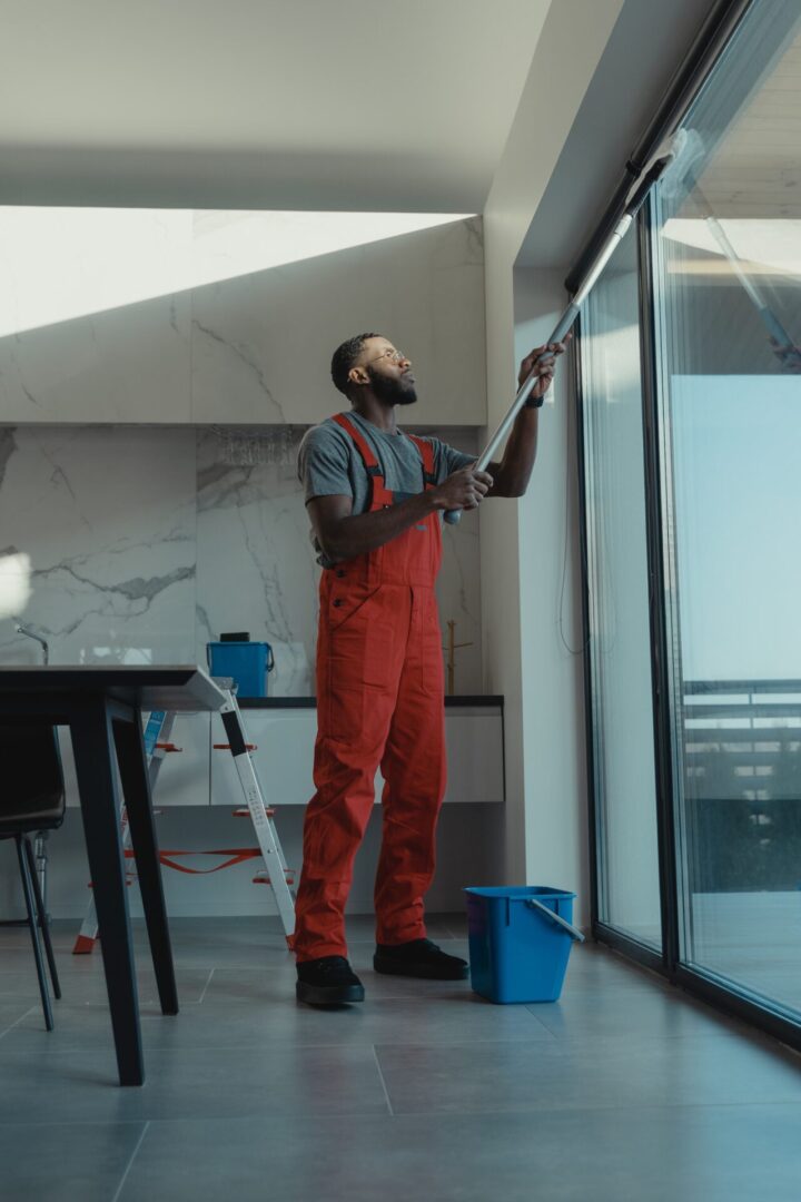 man wiping a sliding glass door